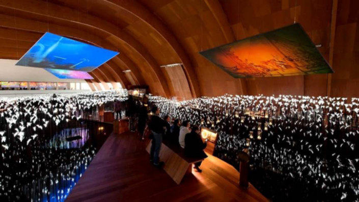 Fig. 5. Navigation Pavilion post transformation: view of new exhibition Area 1 — Sea of Souls — showing the hull-like interior space, timber deck through the LED light sea, interactive settings and overhead projection screens.